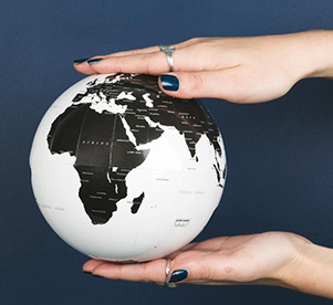 A picture of a globe in someone's hands.